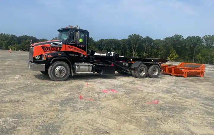 CleanSite truck setting a concrete washout container down on a job site